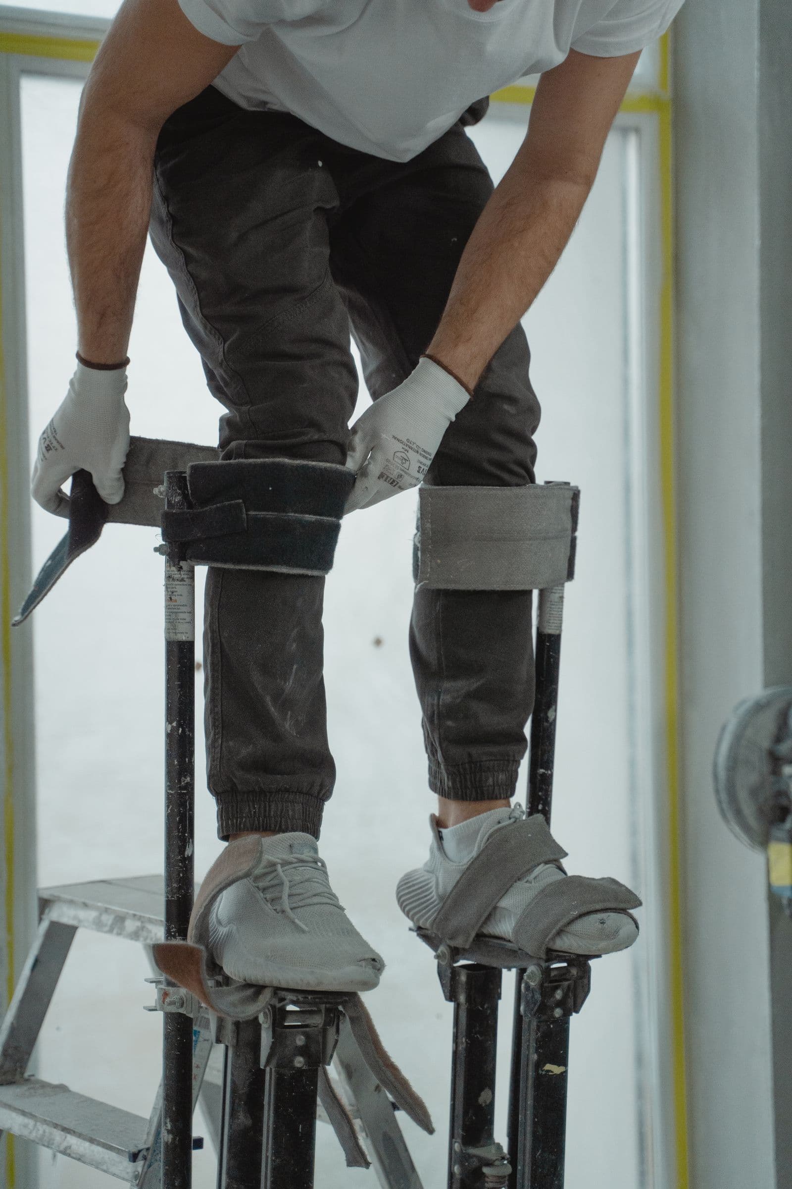 Plasterer working on stilts inside a home renovation